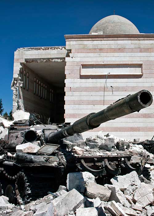 Abandoned tank standing in front of ruined mosque