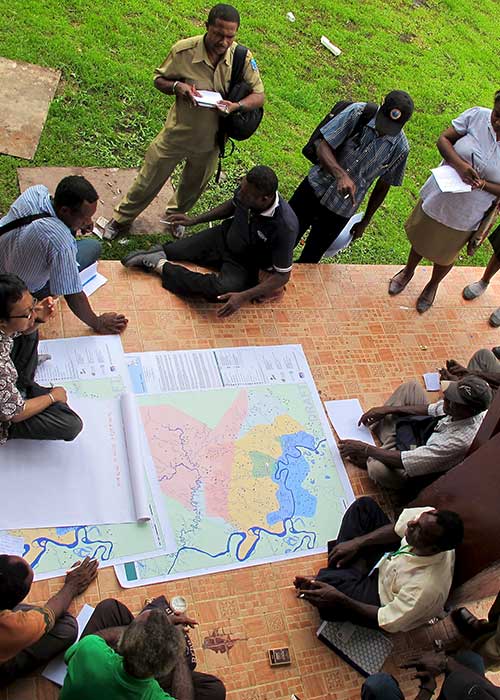 Group of humanitarian workers discussing around a map