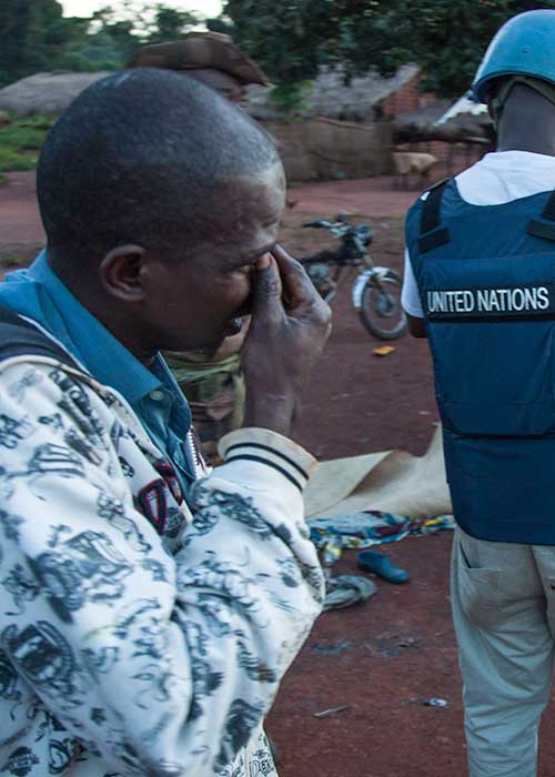 Crying young man behind a UN peacekeeper following an incident