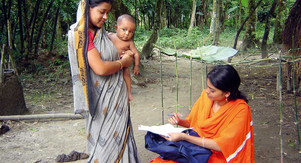 A female interviewer talking to a mother in rural Bangladesh