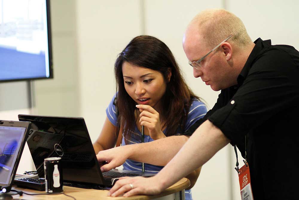 Man discussing with woman by a computer at a conference